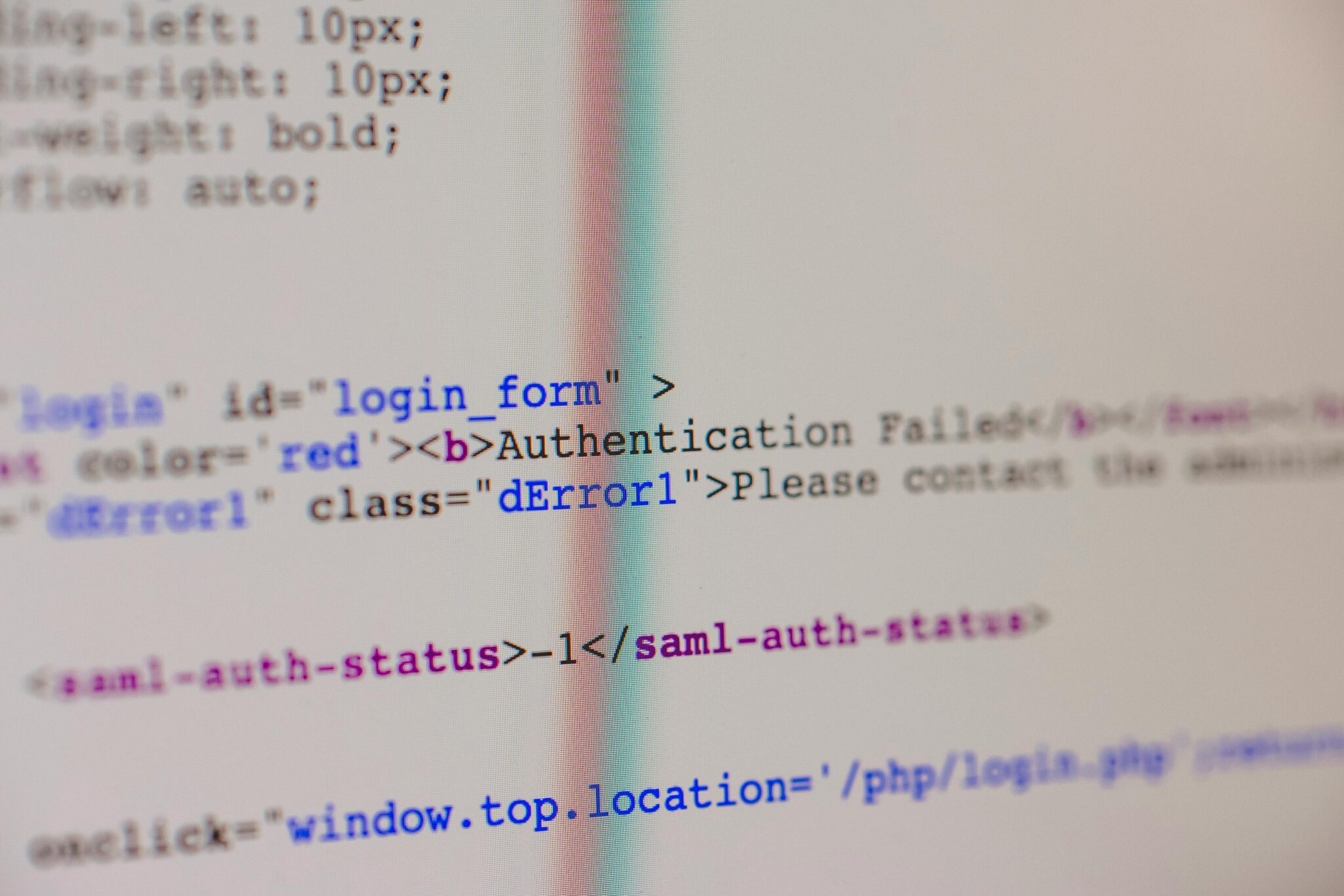 Close-up of HTML and PHP code on screen showing error message and login form data.
