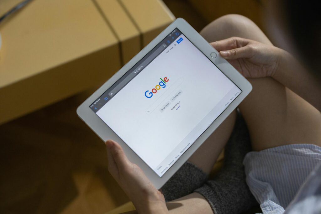 pexels-photo-7350906-7350906 Close-up of hands holding a tablet showing the Google search page.